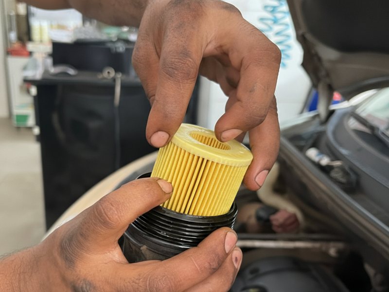 Mecânico substituindo o filtro de óleo do motor durante a troca de óleo